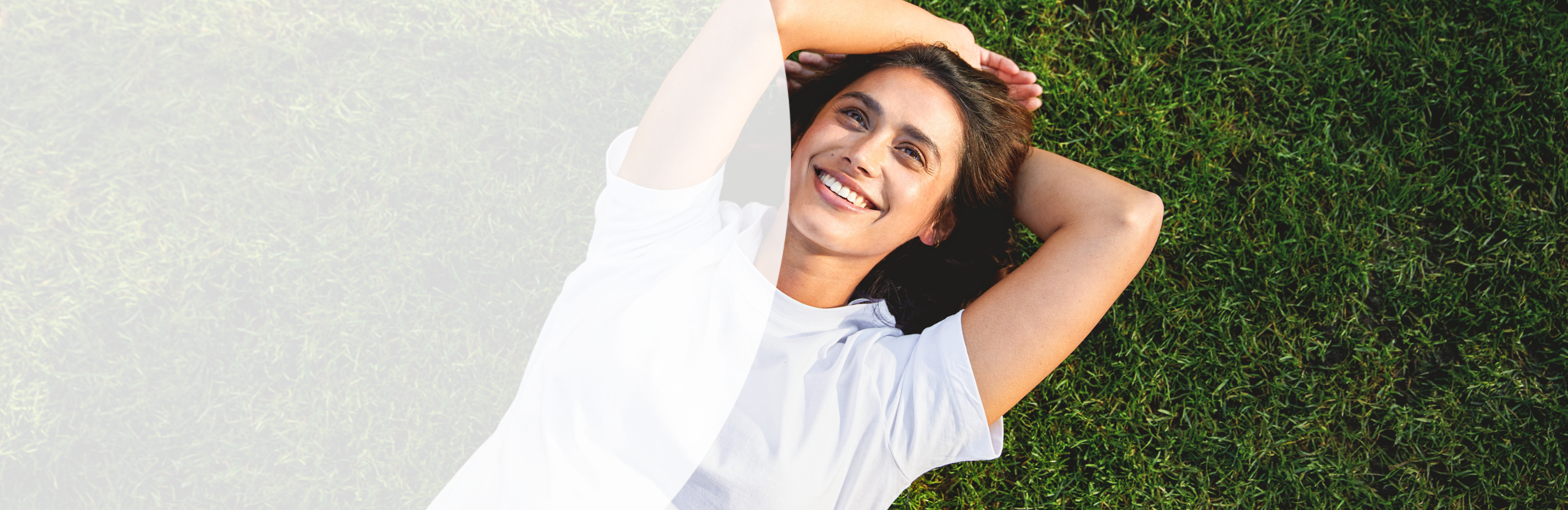 Vrouw liggend in het gras met een gezonde, stralende huid dankzij de Glow Routine van Kneipp.